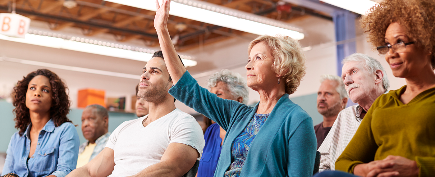 IStock-1145049554 lady with hand up in audience